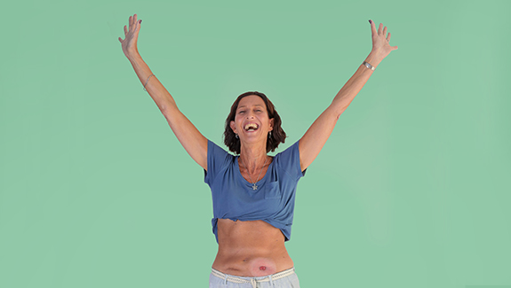 ostomate-woman-with-hands-on-hips-smiling-life-has-a-way-of-throwing-curved-balls-at-you-helens-story